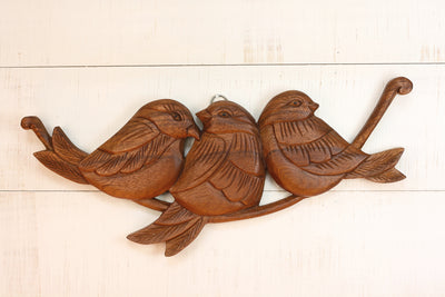 Hand carved wood wall panel featuring three birds on a branch