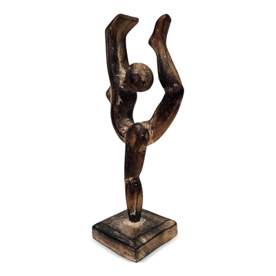 Wooden sculpture of a figure in a dynamic pose on a white background
