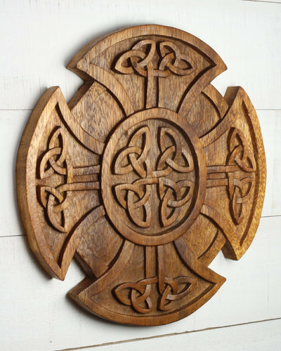 Wooden wall art with Celtic cross design on a white wooden surface