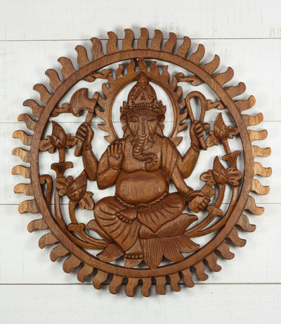 Hand carved wooden wall panel of Ganesha surrounded by sunburst and lotus flowers