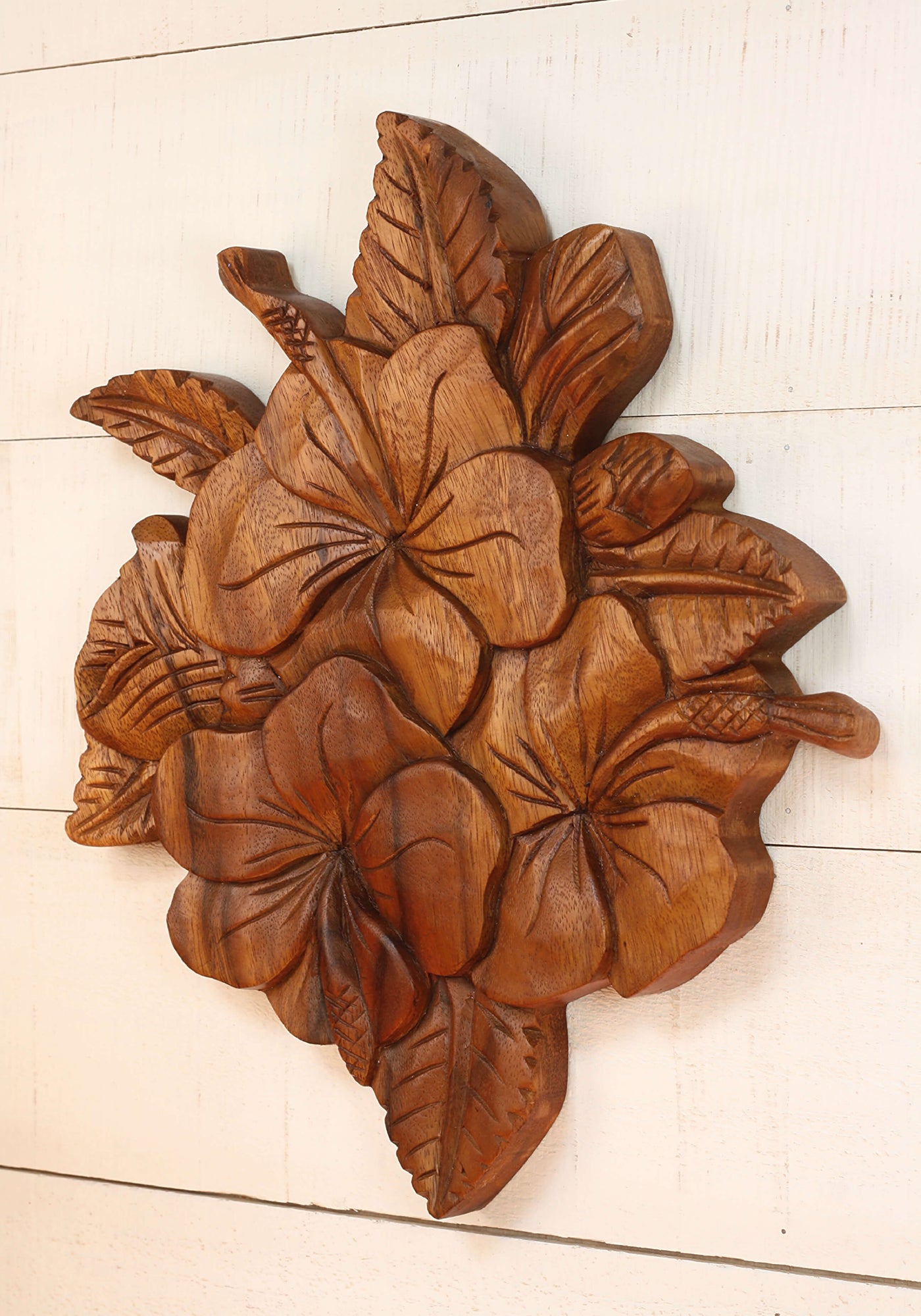 Wooden wall art with floral design on a white wooden surface
