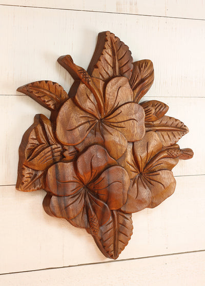 Wooden wall art with leaf patterns on a white wooden surface