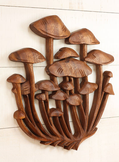 Wooden wall art with carvings of mushrooms on a light background