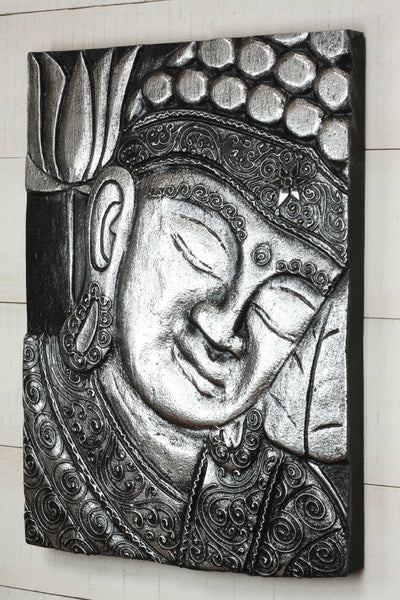 Decorative wall art of a Buddha face with intricate patterns on a black background.