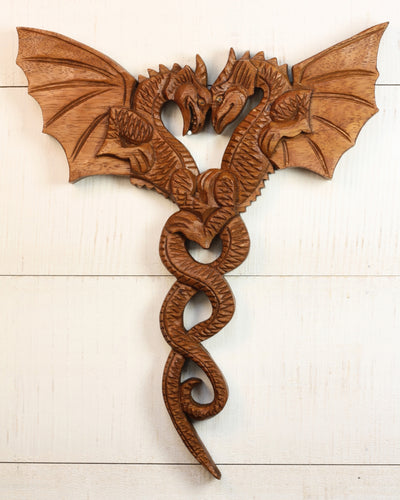 Hand carved wooden wall art of two intertwined dragons with wings