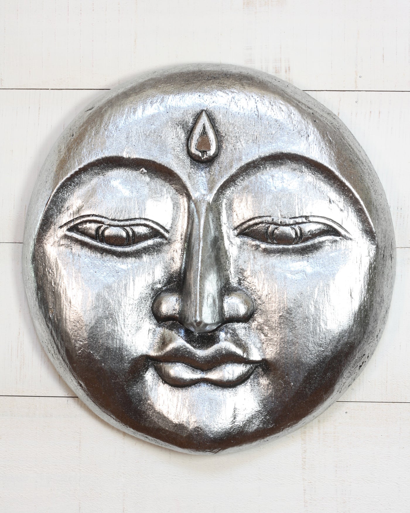Hand carved silver wooden moon face wall sculpture with peaceful expression